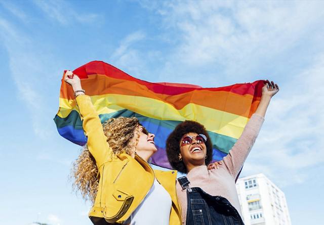 Two women with Pride flag | Blog | Greystar